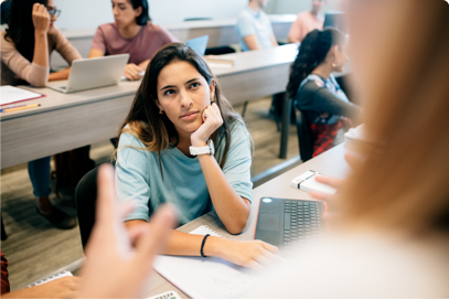 Photo d’une étudiante écoutant attentivement un professeur dans une salle de cours