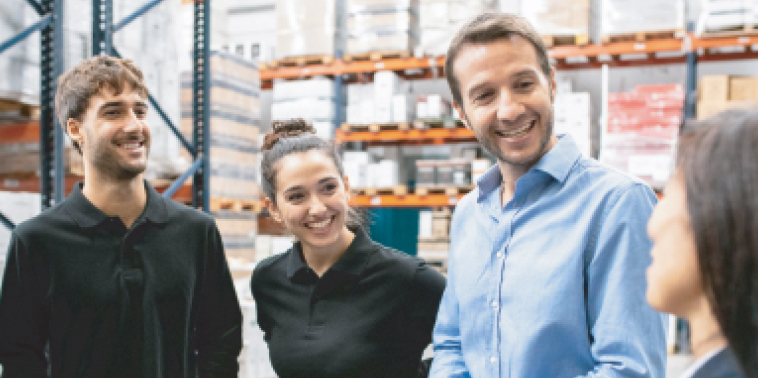 Photo de quatre personnes souriant dans un entrepôt