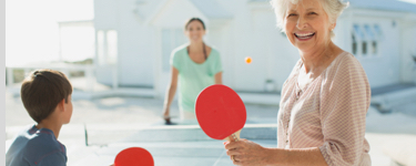 Mère, grand-mère et garçon jouent au ping-pong