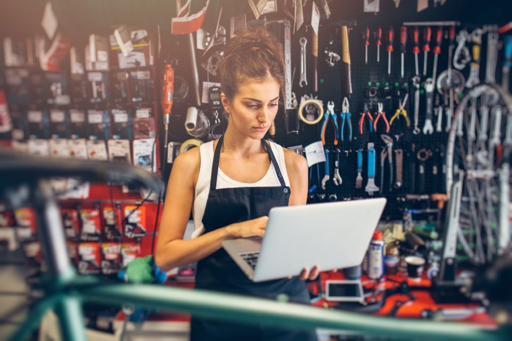 Une femme travaille sur un ordinateur portatif dans un bike shop.