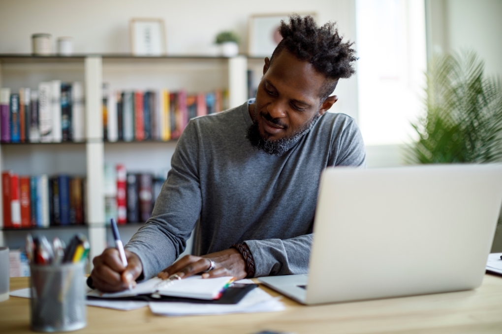 Image pour l’article sur comment faire son budget d’un homme à son bureau faisant son budget Image pour l’article sur comment faire son budget d’un homme à son bureau faisant son budget