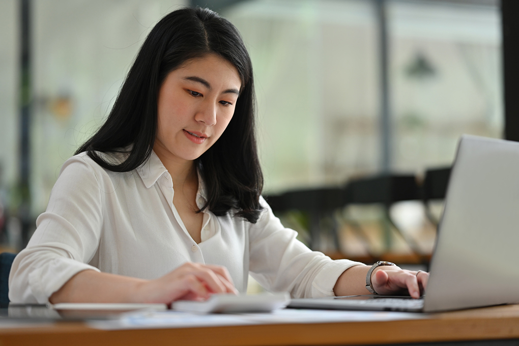 Femme sur un ordinateur suit les finances de sa PME et son crédit 